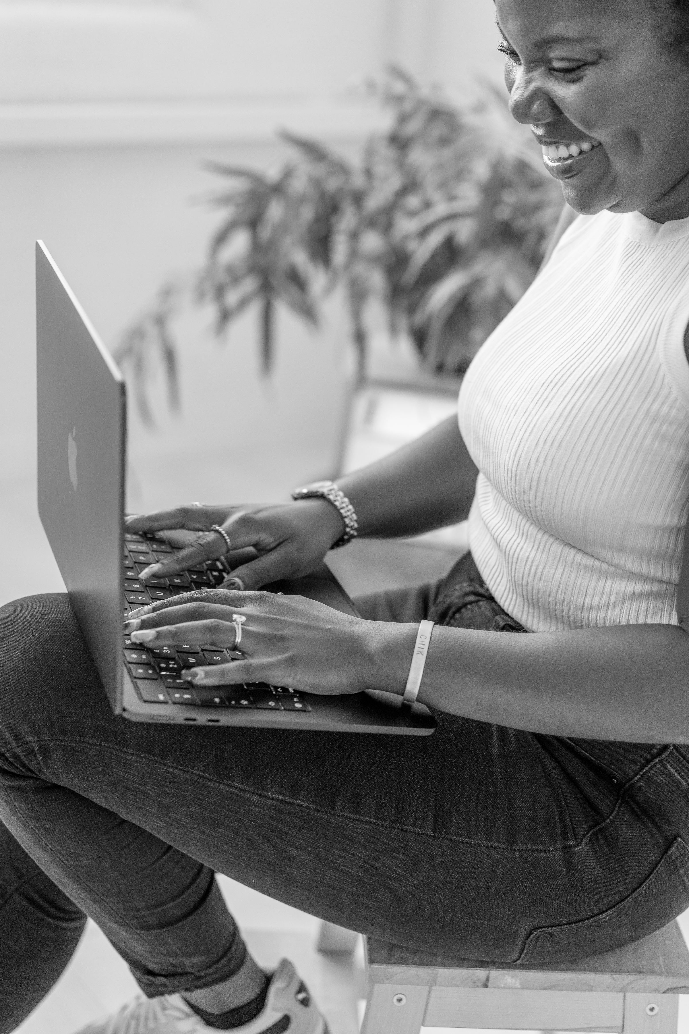 Chikumo Fiseko smiling while working on her laptop